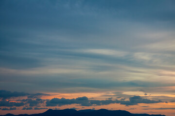 Cinematic romantic warm sky with sunset pastel clouds illuminated by last sun rays before sunset