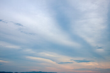 Romantic sky in pastel nude colors with hazy clouds and sunbeam on the horizon surrounded by cinematic environment