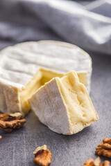 Brie type cheese with white mold. French camembert cheese on kitchen table.
