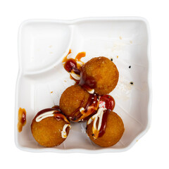 Traditional Takoyaki made of octopus dished up in service plate with soya-bean sauce. Isolated over...