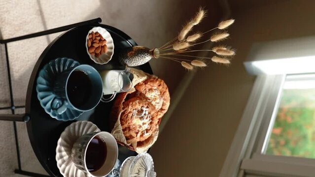 Aesthetic breakfast. Milk coffee, milk tea, sugar, almond, almond cakes, biscuits, marzipans and puffs. British breakfast in a cozy home. Autumn mood. Vertical video.