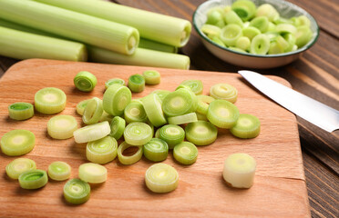 Board and bowl with slices of fresh leek, closeup