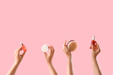Female hands with different skin care products on pink background