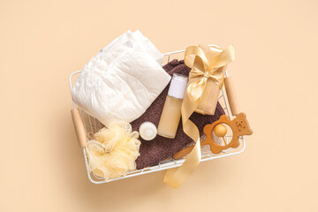 Basket with gifts for baby on beige background