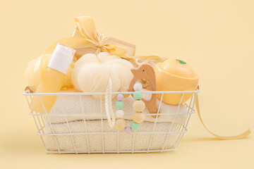 Basket with gifts for baby on beige background