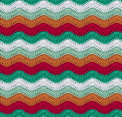 Seamless knitted pattern in the form of zigzags crocheted with threads of contrasting colors. Cotton yarn. African style.