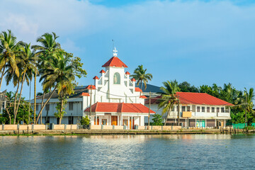 Old colonial Saint Thomas catholic church on the coast of Pamba river, with palms, Alleppey,...