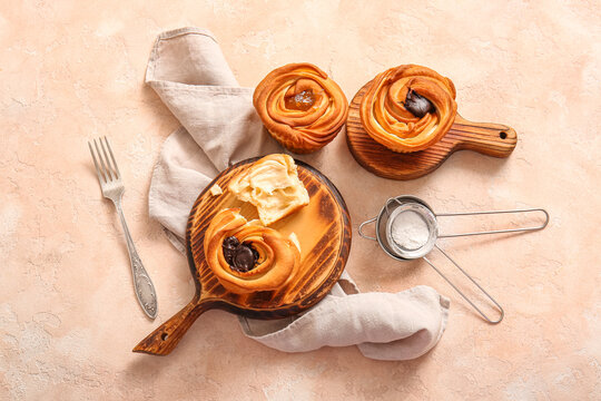 Wooden boards of tasty cruffins with chocolate and jam on beige background