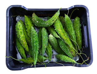 Close-up view of green bitter melons in vegetable box. Isolated over white background