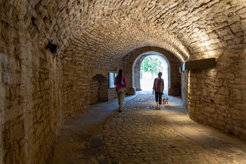 Two women are walking in an ancient tunnel