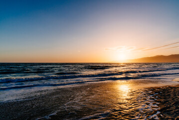 Obraz premium Sunset on the beach reflecting in the ocean