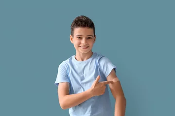 Fotobehang Little boy pointing at plaster after vaccination on blue background © Pixel-Shot