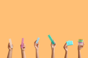 Female hands with different pill boxes on color background