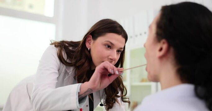 Doctor uses spatula to examine patient throat