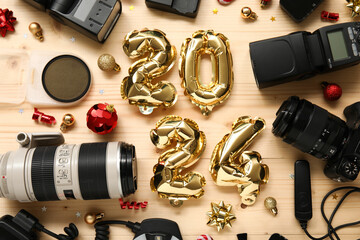 Composition with figure 2024 made of balloons, photographer's equipment and Christmas decorations on wooden background - obrazy, fototapety, plakaty