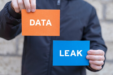 Man holding multi-colored paper cards sees inscription: DATA LEAK. Data leakage concept. Data...