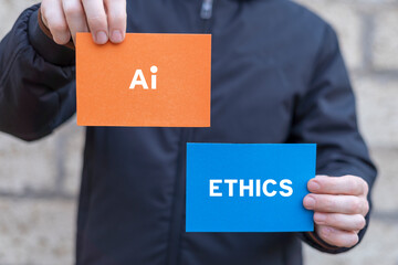 Man holding multi-colored paper cards sees inscription: AI ETHICS. AI ethics or AI Law concept. Developing AI codes of ethics.
