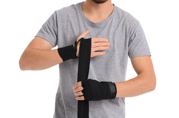 Young man wrapping hands with boxing wraps on white background. Concept of self defense