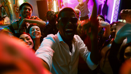 POV of funky people filming video at party, making memories on dance floor with friends at...