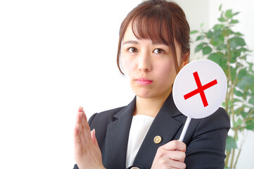 バツのプレートを持つ女性弁護士