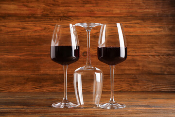 Glasses with red wine on wooden background