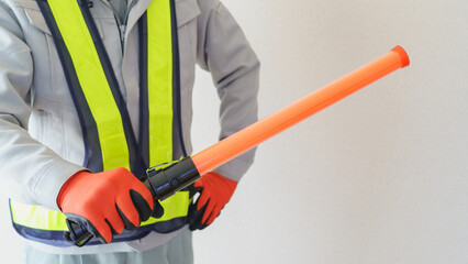 誘導棒を持つ作業服の男性｜建設業・警備員・ガードマン　イメージ