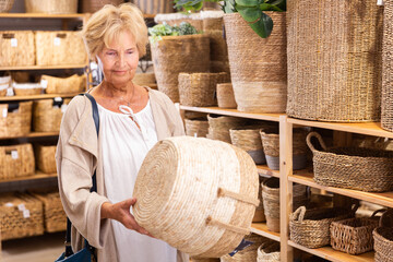 Portrait of mature woman buying storage basket in a household goods store