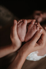 mother's hands holding baby's legs