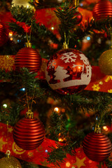 Close-up of red and gold Christmas ornaments on a Christmas tree