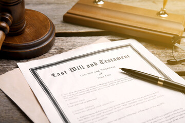 Last Will and Testament, pen and gavel on wooden table, closeup