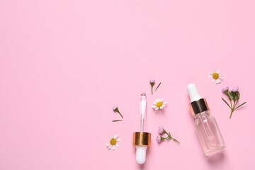 Bottle of cosmetic serum, pipette and beautiful flowers on pink background, flat lay. Space for text