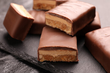 Tasty chocolate bars with nougat on gray table, closeup