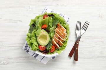 Delicious salad with chicken, cherry tomato and avocado served on white wooden table, top view