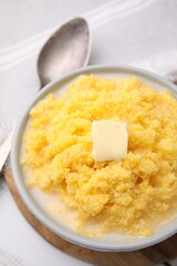 Tasty cornmeal with butter in bowl served on table, above view