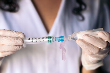 nurse injecting serum into a syringe