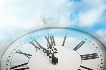 Time concept. Double exposure of blue sky with fluffy clouds and clock