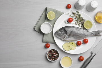 Flat lay composition with raw dorado fish on white wooden table. Space for text