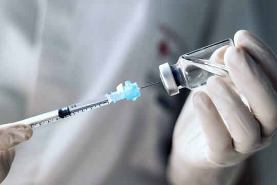 injecting injection vaccine vaccination medicine covid into a syringe woman nurse. Close-up