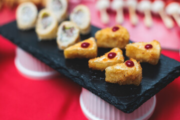 Catering table, beautifully decorated banquet with variety of with different food snacks appetizers on corporate birthday party event or wedding celebration, canape, salad, delicatessen setting
