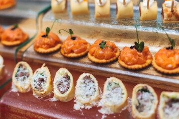 Catering table, beautifully decorated banquet with variety of with different food snacks appetizers on corporate birthday party event or wedding celebration, canape, salad, delicatessen setting