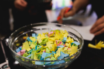 Process of prize drawings, extracting a winning numbers of lottery machine, raffle drum with a bingo balls, bingo machine and winning tickets on event with a host, hands on lottery machine