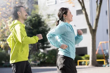 Foto op Plexiglas 都会の街中をジョギングやランニングする男女 © kapinon