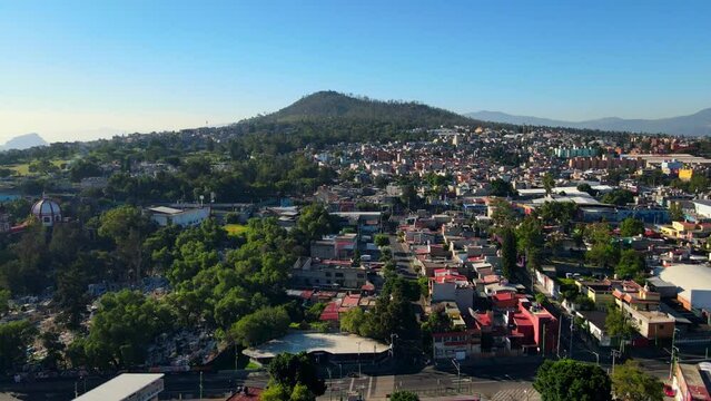 Aerial view establishing Iztapalapa south of Mexico City, Cerro de la Estrella National Park. Sunny day, low development area