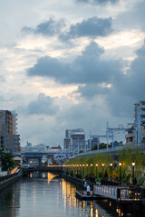 cloudy sunset over a canal in central tokyo along an elevated train line