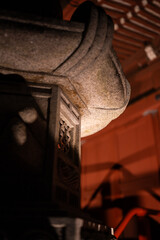 japanese stone lantern lit from the side at night at a temple in tokyo japan