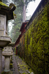 old stone wall along a stone road on the side of a japanese shrine