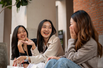 A beautiful young Asian female is enjoying talking with her friends while resting on the stairs.