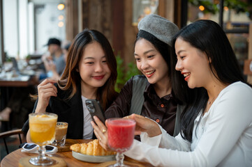Group of cheerful and attractive Asian female friends are enjoying hanging out at a cafe.