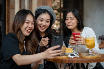 Group of cheerful and attractive Asian female friends are enjoying hanging out at a cafe.