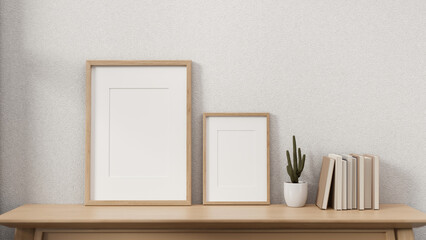 Minimal wooden picture frames on a wooden table against the white wall in a cosy Scandinavian room.